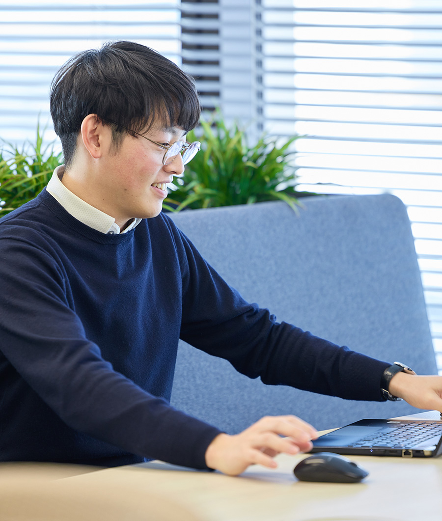 工場内で作業着を着た男性若手社員。手にはヘルメットを抱えている