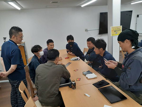 室内のテーブルに座っている人々の集まり