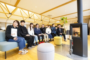 オフィスのソファで記念撮影。正面では暖炉が焚かれている。