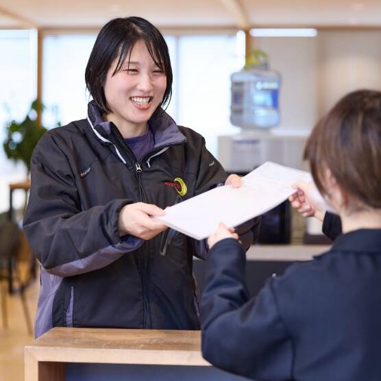 クリアファイルに入った書類を受け取る女性