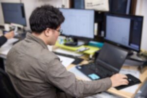 パソコンを使って、設計図を基に図面を作るCADのオペレーターのイメージ