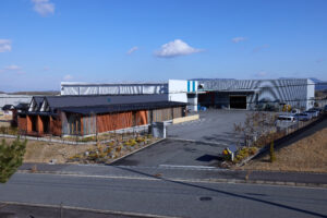 京都府木津川市にある京都工場。左手前にカフェのような事務所、左手奥に開発・品証棟、右手奥に工場棟が見える。
